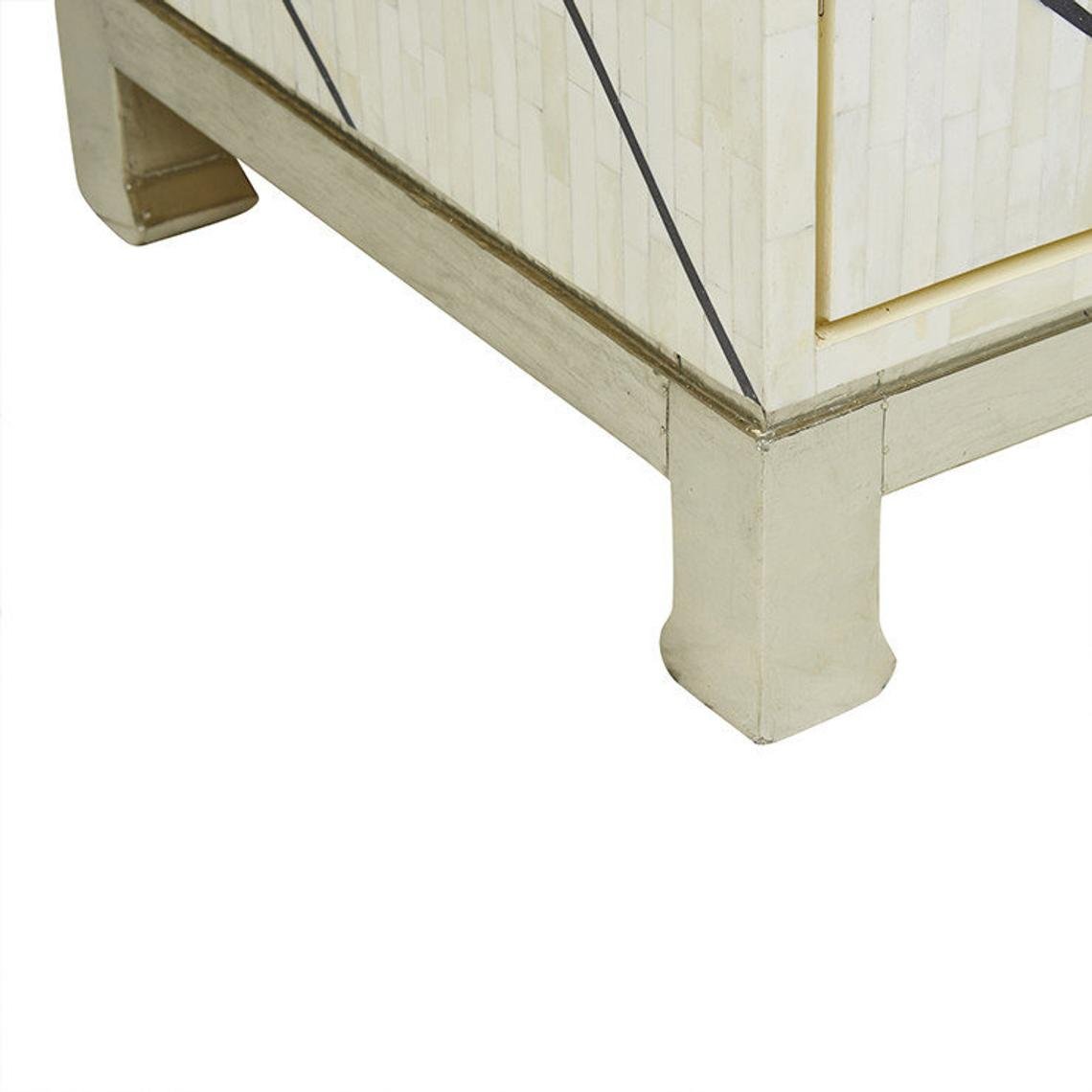 Lower corner of bone inlay sideboard showing solid silver metal leg, gold trim border, and ivory geometric inlay panel with black line accents