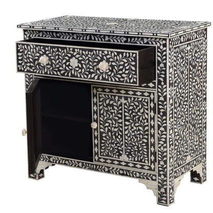 Black bone inlay cabinet with open top drawer and open left door revealing interior shelving, intricate ivory floral vine inlay on charcoal base
