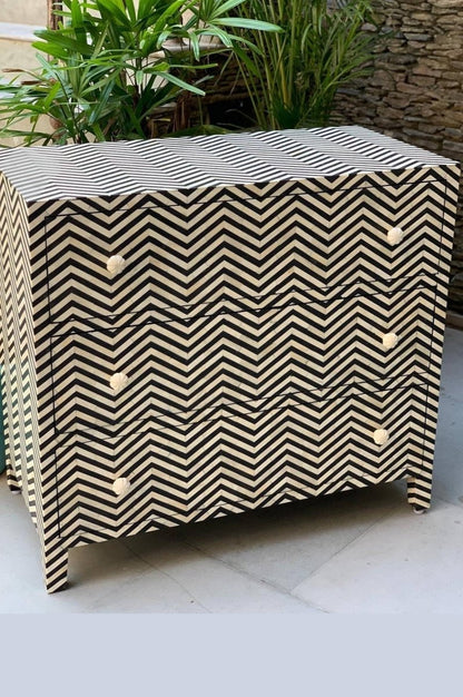Three-drawer black and white bone inlay dresser featuring a continuous herringbone zig-zag pattern and white floral knobs.